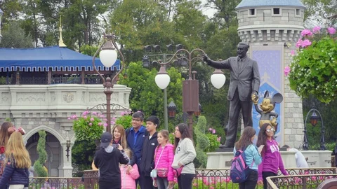 4K Walt Disney Statue surrounded by Families on vacation at Disney World Park Stock Footage 123933526