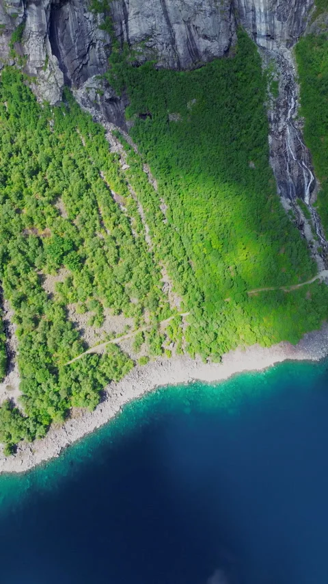 4K Waterfall Cascading from Cliffs into Serene Landscape, Trolltunga, Norway Stock Footage 296021976
