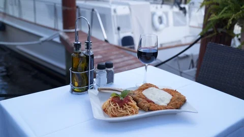 4k Waterfront dining, chicken parmesan and wine. 스톡 동영상 122937982