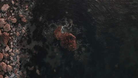 4K waves breaking over a small rock at sunset off the Welsh coast Stock Footage 233119956