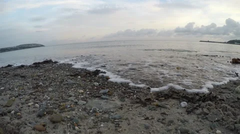 4K waves rolling in on pebbly sandy beach with audio Stock Footage 46123443