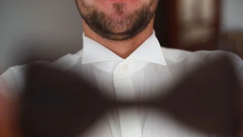 4k Wearing bow tie close up. Male hands check correct and adjust casual bow tie Stock Footage 107771008