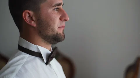 4k Wearing bow tie close up. Male hands check correct and adjust casual bow tie Stock Footage 107771514
