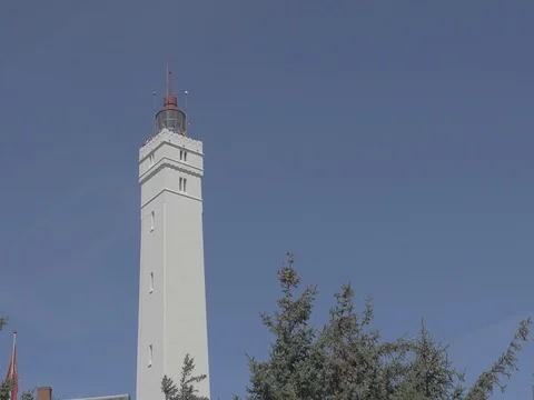 4k white lighthouse behind trees at noon Video stock 75078449