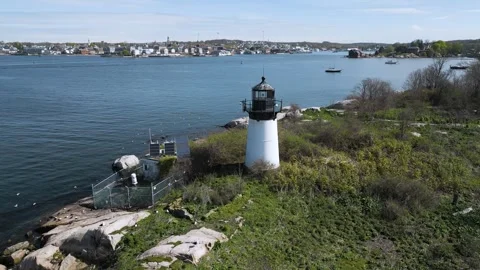 4k White lighthouse on a small island aerial pan Stock Footage 240313369