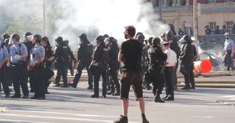 4K WHITE MAN WATCHING AS COPS GET TOGETHER DURING PROTEST Stock Footage 131455996