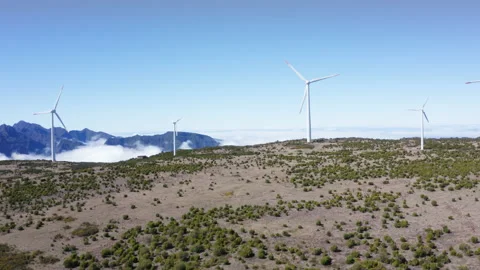 4K wide angle footage of wind turbines rotating in field with clear sunny sky Stock-Footage 201762510