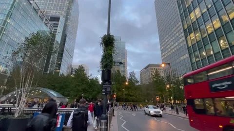 4K wide angle panning Canary Wharf peak hours greyish day with buses, taxi rank Stock Footage 220033583