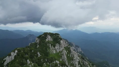 4K wide drone orbit around mountain summit – dramatic alpine scenery Stock Footage 344547567