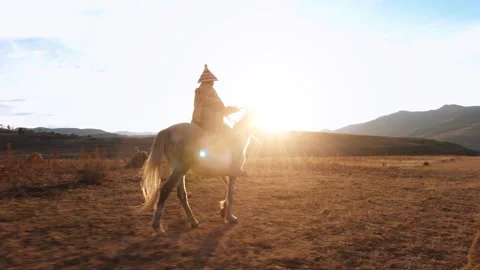 4k wide of an old African authentic herder/ horse man riding his white horse on Stock Footage 199616229