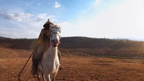 4k wide of an old African authentic herder/ horse man riding his white horse on 動画素材 199616290