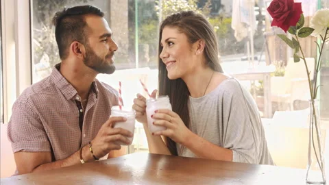 4k wide video of multicultural dating couple drinking milkshakes in cafe. Видео 201094933
