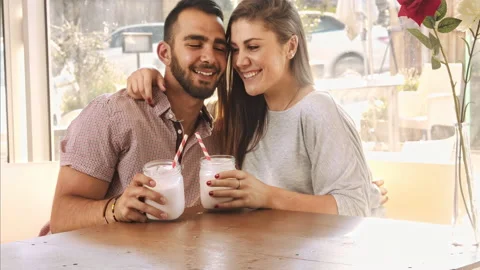 4k wide video of multicultural dating couple drinking milkshakes in cafe. Stock Footage 201095315