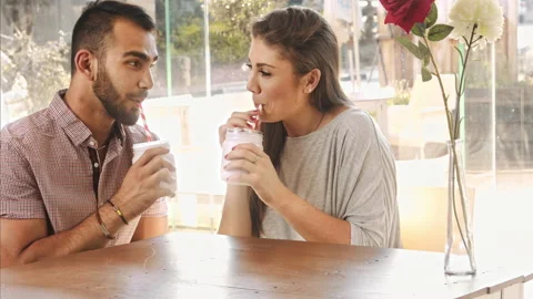 4k wide video of multicultural dating couple drinking milkshakes in cafe. Видео 201096153
