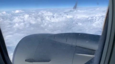 4k Window seat on airplane overlooking clouds. Jet engine on the wing , on fly Stock Footage 147995703