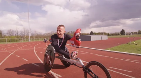 4K Winning disabled athlete at racing event doing victory lap with British flag. Stock Footage 64569629