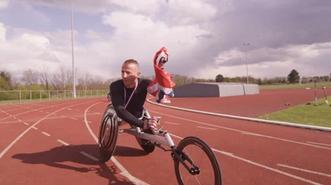 4K Winning disabled athlete at racing event doing victory lap with British flag Stock Footage 64659618