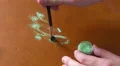 4K Woman is brushing green makeup glitter together on a brown table 4k or 4k+ Resolution