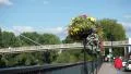 4K woman in red walks towards bridge with flowers by the river 4k or 4k+ Resolution