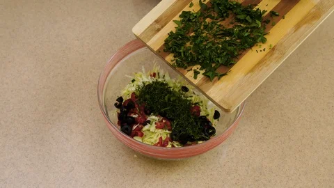 4k. Woman’s hands are adding the parsley from a  board into a glass plate Stock Footage 128329228