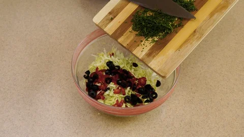 4k. Woman’s hands are adding the dill from a board into a glass plate Stock Footage 128329256