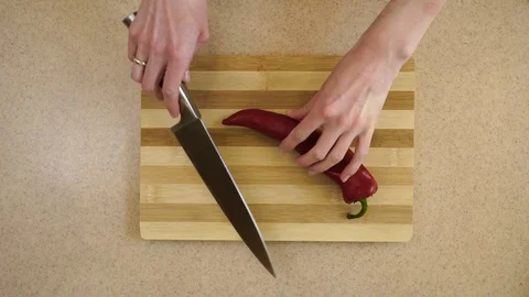 4K. Woman’s hands are cutting red pepper Kapi on the rings on a kitchen board Stock Footage 128329145
