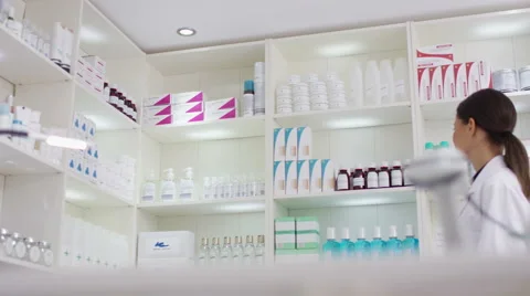 4K Worker in a pharmacy putting a bottle of natural medicine onto shop counter Stock Footage 58334462