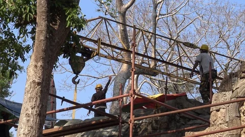 4K Workers in the construction with scaffolding and crane at Ta Prohm temple-Dan Stock Footage 119060012