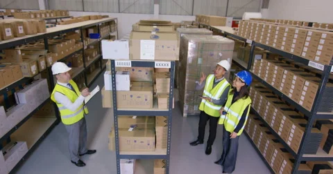 4k Workers in industrial warehouse checking stock & preparing goods for dispatch Stock Footage
