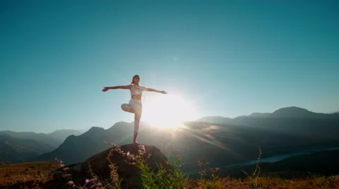 4K yoga in the mountains,a beautiful girl dressed in white ,sun,sun flare, slow Stock Footage