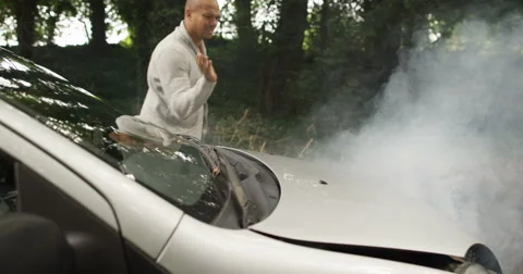 4k, Young African American man walks to look under the hood of a broken down car Video stock 68289727