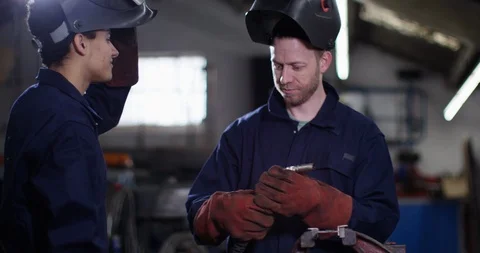 4K Young apprentice being trained by experienced colleague in garage workshop Video stock 111633109