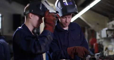 4K Young apprentice learning from experienced worker in metalwork factory Stock Footage 111639260