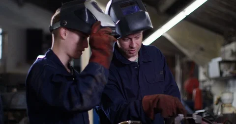 4K Young apprentice learning from experienced worker in metalwork factory Stock Footage 113101001