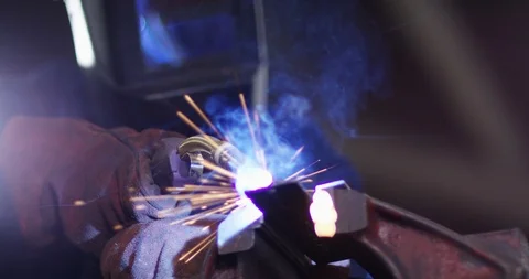 4K Young apprentice metalworker lifting up visor &amp; smiling to camera Stock Footage 111653395