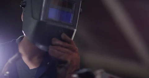 4K Young apprentice metalworker lifting up visor &amp; smiling to camera Stock Footage 113105943