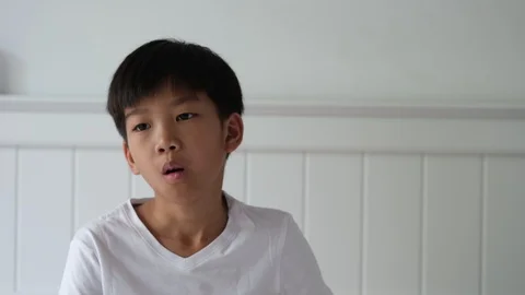 4k Young Asian boy get cough and take a mask to wear Stock Footage 125553162