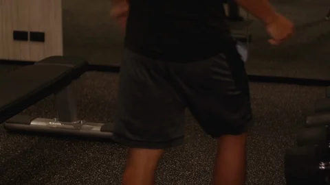 4k Young Asian man doing dumbbell leg lunges exercise at the gym, evening, Stock Footage 121189251