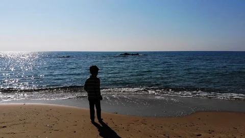 4k young barefooted child shadow jumping on sandy sea shore on sunny day Stock Footage 105760095