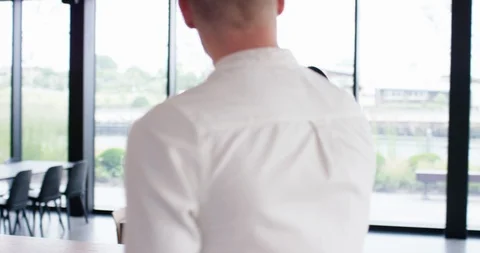 4K Young businessman walking through trendy office, looking at tablet &amp; smiling Stock Footage 118963582