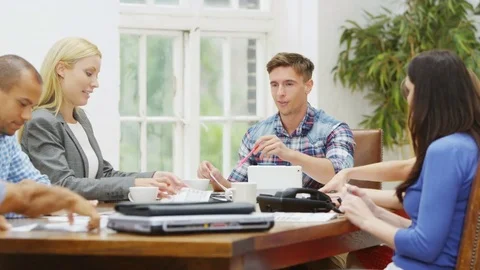 4K Young casual business team looking over the figures in company meeting Stock Footage