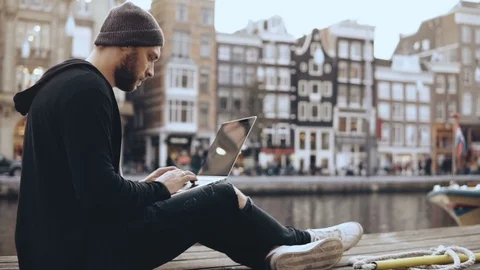 4K Young Caucasian man works with laptop outside. Creative worker looking for Stock Footage