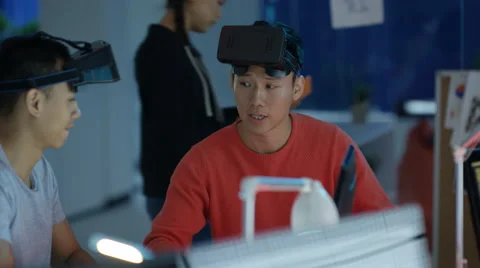 4K Young computer game designers looking into VR viewers &amp; discussing a project. Stock Footage 67516810