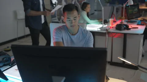 4K Young computer game designers in dark office, man watching computer screens 스톡 동영상 67902102