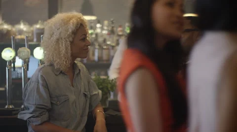 4K Young couple chatting &amp; bartender serving drinks in trendy city bar. Stock Footage 64531978