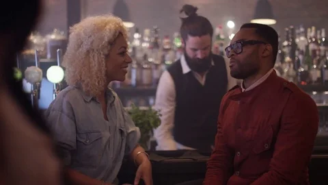 4K Young Couple Chatting &amp; Bartender Serving Drinks In Trendy City Bar Stock Footage 75594285