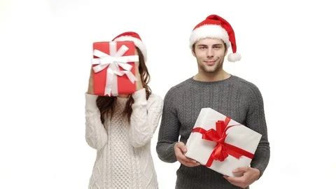 4k young couple playing and hiding behind Christmas present box on white Stock Footage 85240318