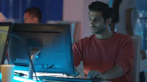 4K Young creative computer game designer working with colleagues in dark office. Stock Footage 67898827