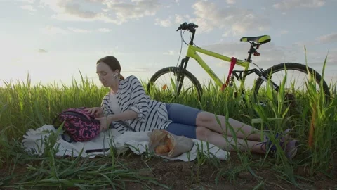 4K. A young cyclist is resting in a field. Stock Footage 201060427
