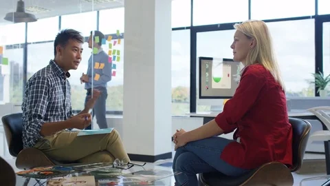 4K Young designers collaborating on a project in creative office Stock Footage 76023146